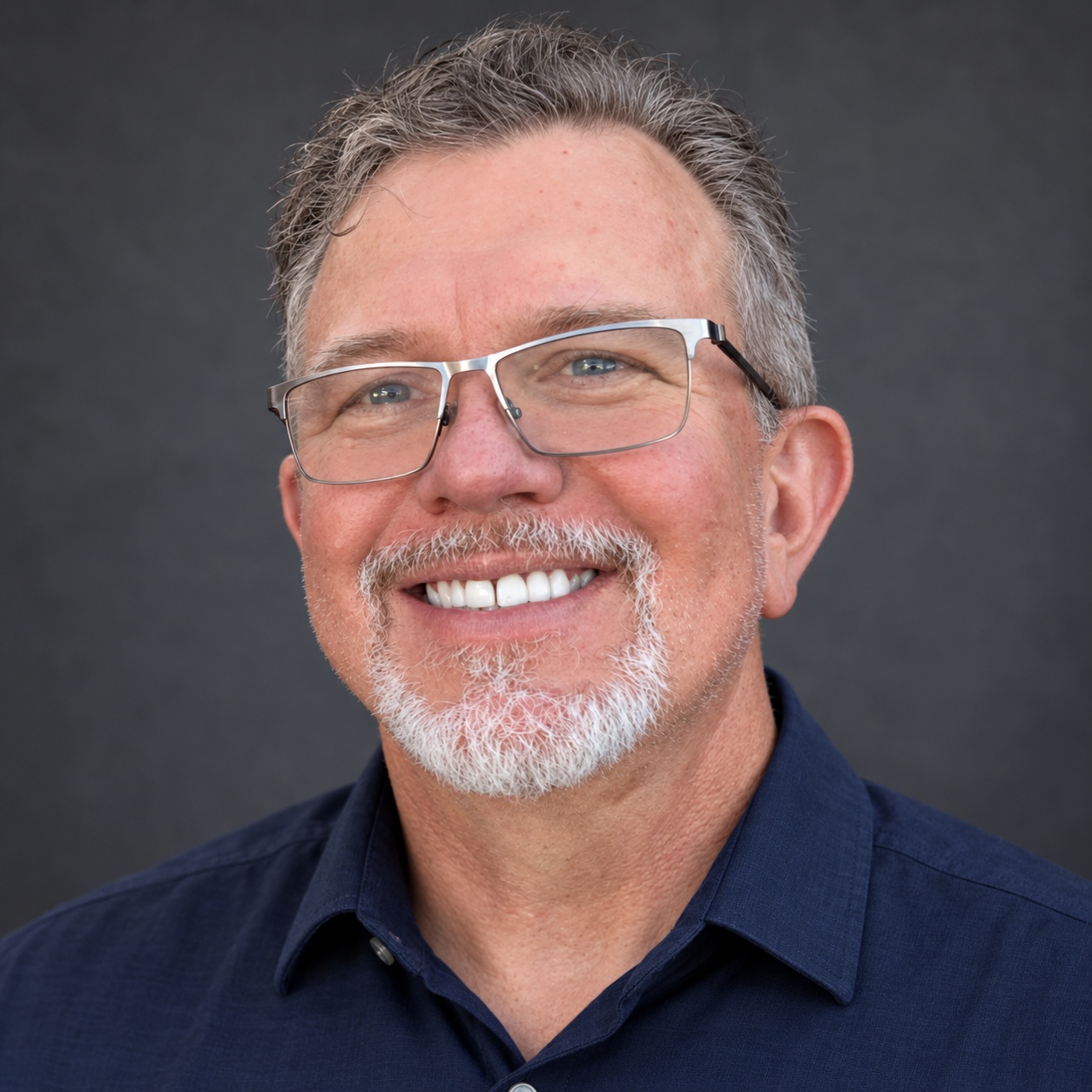 Rob Long, smiling in a navy collared shirt