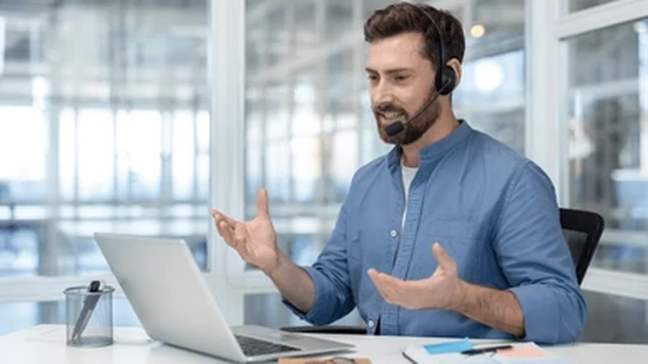 A sales professional speaking on the phone at a desk to follow up on new leads.